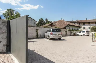 a car parked in a parking lot next to a wall at Apartment Residence Veronika in Ora/Auer