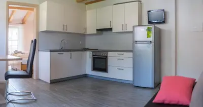a kitchen with white cabinets and a refrigerator at Apartment Residence Veronika in Ora/Auer