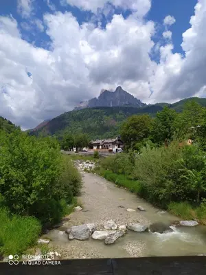 a river with a mountain in the background at La casa dello scoiattolo primierotto in Tonadico