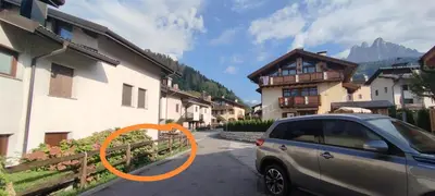 a car parked next to a building with an orange circle at La casa dello scoiattolo primierotto in Tonadico