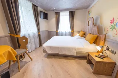 a hotel room with a bed and a table and a desk at Agritur Casa Fabri in Coredo