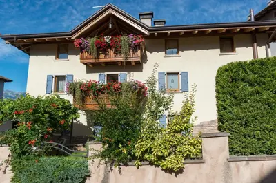 a building with flower boxes on it at Agritur Casa Fabri in Coredo
