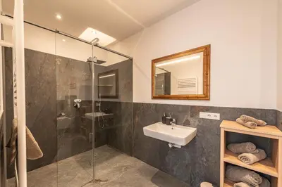 a bathroom with a sink and a glass shower at Residence 1963 - Apartments in Termeno