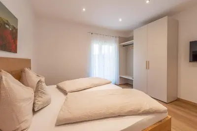 two beds in a bedroom with white walls at Residence 1963 - Apartments in Termeno