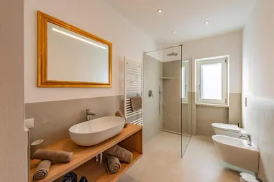 a bathroom with a tub and a sink and a mirror at Residence 1963 - Apartments in Termeno