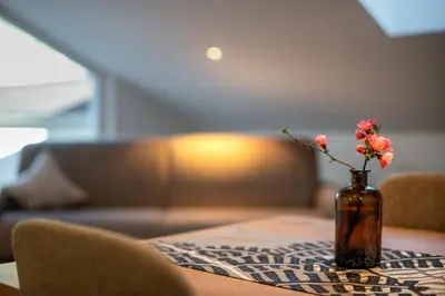 a vase on a table with a flower in it at Residence 1963 - Apartments in Termeno
