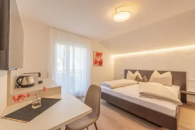 a bedroom with a bed and a table and a desk at Residence 1963 - Zimmer in Termeno