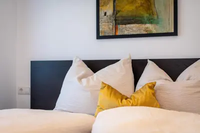 a bed with white pillows and a painting on the wall at Residence 1963 - Zimmer in Termeno