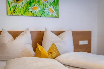 a bed with white pillows and a painting on the wall at Residence 1963 - Zimmer in Termeno
