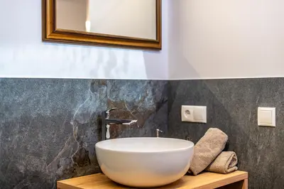 a bathroom with a white bowl sink on a wooden table at Residence 1963 - Zimmer in Termeno