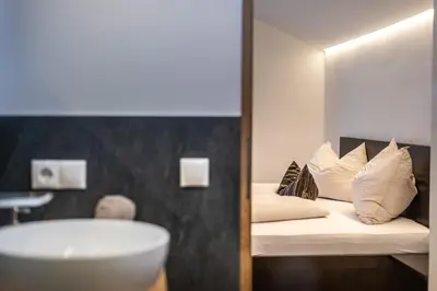 a bathroom with a bed and a sink and a tub at Residence 1963 - Zimmer in Termeno