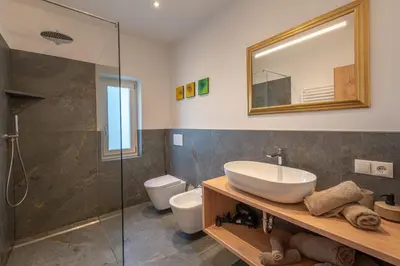 a bathroom with a sink and a toilet and a mirror at Residence 1963 - Zimmer in Termeno