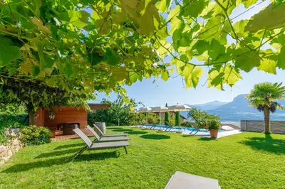 a yard with lounge chairs and a swimming pool at Runggnerhof in Termeno