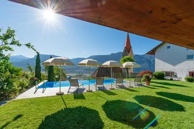 a group of chairs and umbrellas in a yard at Runggnerhof in Termeno