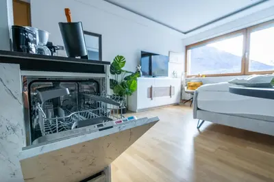 a living room with a fireplace and a bed at Ausblick Kleinjuwel mit Panoramablick + Garage in Merano