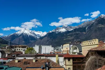 a city with snow capped mountains in the background at Ausblick Kleinjuwel mit Panoramablick + Garage in Merano