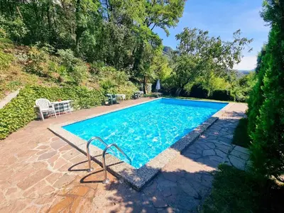 a swimming pool with a chair next to it at Suite Castel MeranO - panorama terrace and pool in Merano