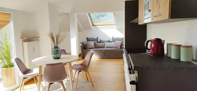 a kitchen and living room with a table and chairs at Suite Castel MeranO - panorama terrace and pool in Merano