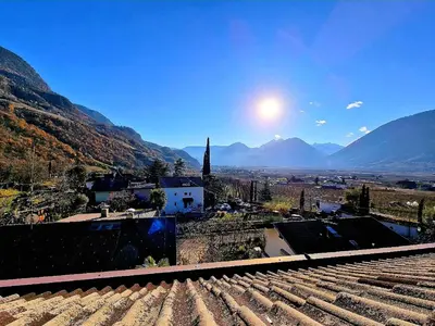a view of a town with mountains in the background at Suite Castel MeranO - panorama terrace and pool in Merano