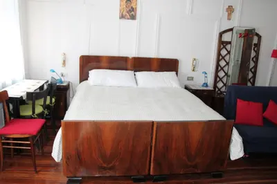 a bed with a wooden frame in a room at Dolomites Holidays in Selva di Cadore