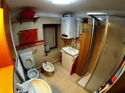 a small bathroom with a toilet and a sink at Dolomites Holidays in Selva di Cadore