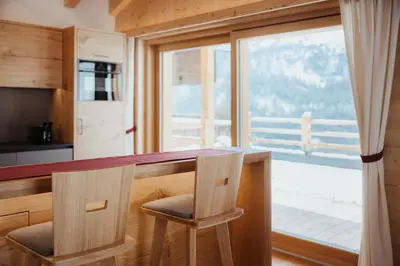 a kitchen with a table with two chairs and a window at Chalet Lärchenhof in Colfosco