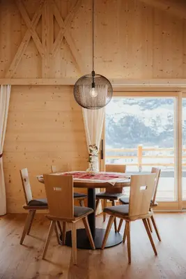 a dining room with a table and chairs and a large window at Chalet Lärchenhof in Colfosco