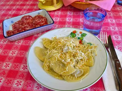 a plate of nachos with cheese and a bowl of salsa at La Casa di Carlotta in Alleghe