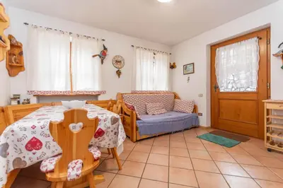 a living room with a table and a chair at La Casa di Carlotta in Alleghe