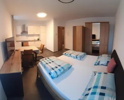 a large bedroom with two beds and a kitchen at Lanziner Apartments in Egna