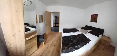 two beds in a room with wooden floors at Lanziner Apartments in Egna