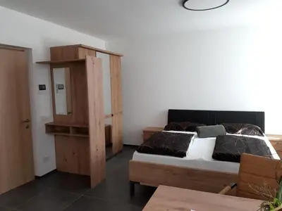 a bedroom with a bed and a wooden cabinet at Lanziner Apartments in Egna