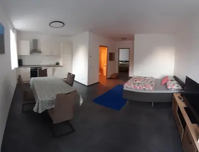 a living room with a table and a dining room at Lanziner Apartments in Egna