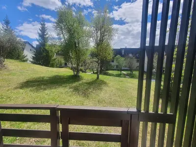 a view of a park from a wooden bench at Oasi Verde - Alpine Stay Apartments in Carano
