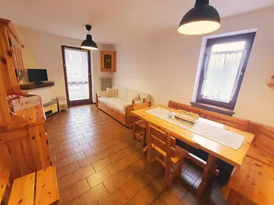 a living room with a table and a couch at Oasi Verde - Alpine Stay Apartments in Carano