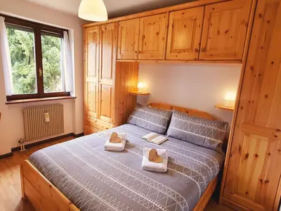 a bedroom with a bed with two towels on it at Oasi Verde - Alpine Stay Apartments in Carano
