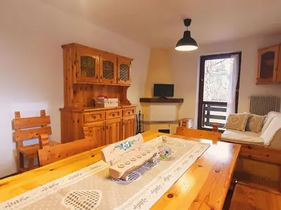 a living room with a table and a couch at Oasi Verde - Alpine Stay Apartments in Carano