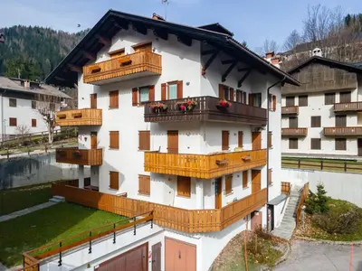 a white building with wooden balconies on it at Appartamento Sandra - Molino in Falcade