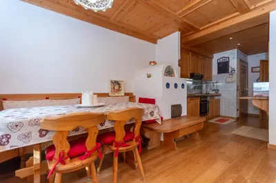 a kitchen and dining room with a table and chairs at Appartamento Sandra - Molino in Falcade