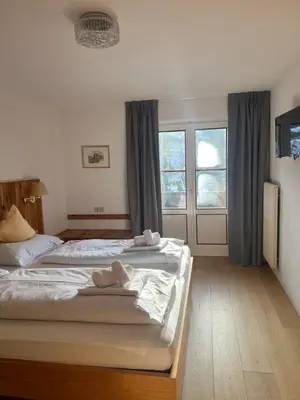 a bedroom with two beds with towels on them at LAKE & RIVER Hotel in Carezza al Lago