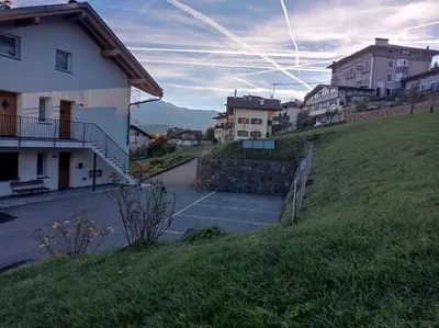 a parking lot with a tennis court in a city at Varesco Appartamenti in Carano