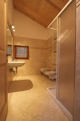 a bathroom with two sinks and a shower at Varesco Appartamenti in Carano
