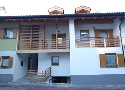 a building with wooden balconies on the side of it at Varesco Appartamenti in Carano