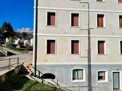 a building with windows on the side of a street at home in dolomiti in Villanova