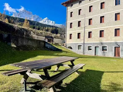 a wooden picnic table in a field next to a building at home in dolomiti in Villanova