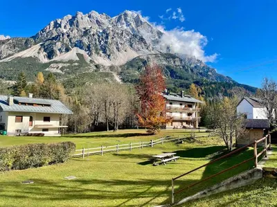 a house in a field with a mountain in the background at home in dolomiti in Villanova