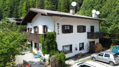a house with cars parked in front of it at Appartamenti Callori Karin in Canazei