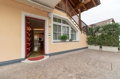 a house with a red door and a patio at Ba mir Apartment in Appiano sulla Strada del Vino