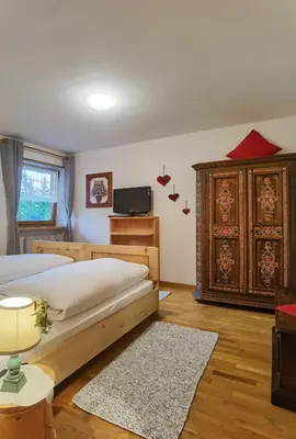 a bedroom with a bed and a dresser at Apartment Enrosadira Pedraces in Badia