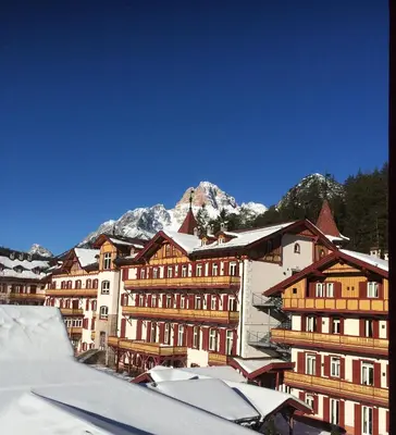 a group of buildings with a mountain in the background at Villaggio Turistico Ploner in Carbonin